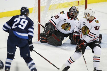 Winnipeg Jets' Patrik Laine (29) scores his second goal of the night on Chicago Blackhawks goaltender Corey Crawford (50) as Gustav Forsling (42) defends during third period NHL action in Winnipeg on Thursday, November 29, 2018. THE CANADIAN PRESS/John Woods