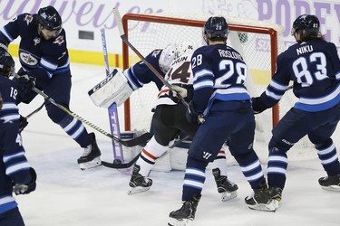 Chicago Blackhawks' Dominik Kahun (24) scores on Winnipeg Jets goaltender Connor Hellebuyck (37) during third period NHL action in Winnipeg on Thursday, November 29, 2018. THE CANADIAN PRESS/John Woods