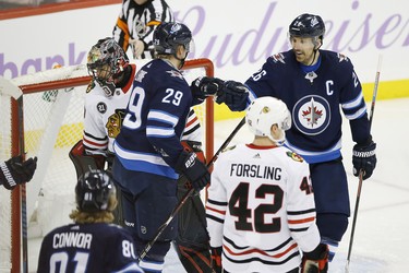 Winnipeg Jets' Patrik Laine (29) and Blake Wheeler (26) celebrate Laine's second goal of the night on Chicago Blackhawks goaltender Corey Crawford (50) during third period NHL action in Winnipeg on Thursday, November 29, 2018. THE CANADIAN PRESS/John Woods