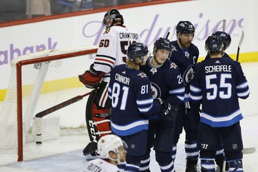 Winnipeg Jets' Kyle Connor (81), Patrik Laine (29), Blake Wheeler (26) and Mark Scheifele (55) celebrate Laine's second goal of the night on Chicago Blackhawks goaltender Corey Crawford (50) during third period NHL action in Winnipeg on Thursday, November 29, 2018. THE CANADIAN PRESS/John Woods