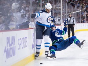 Winnipeg Jets' Dustin Byfuglien (33) fights off Vancouver Canucks' Tim Schaller (59) during the first period of an NHL hockey game in Vancouver, on Monday November 19, 2018. THE CANADIAN PRESS/Darryl Dyck