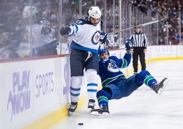 Winnipeg Jets' Dustin Byfuglien (33) fights off Vancouver Canucks' Tim Schaller (59) during the first period of an NHL hockey game in Vancouver, on Monday November 19, 2018. THE CANADIAN PRESS/Darryl Dyck