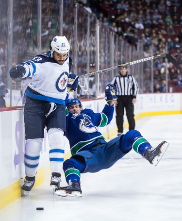 Winnipeg Jets' Dustin Byfuglien (33) fights off Vancouver Canucks' Tim Schaller (59) during the first period of an NHL hockey game in Vancouver, on Monday November 19, 2018. THE CANADIAN PRESS/Darryl Dyck