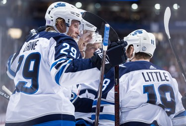 Winnipeg Jets' Patrik Laine (29), of Finland, Bryan Little (18), Tyler Myers, second left, and Joe Morrow, back, celebrate Little's goal against the Vancouver Canucks during the first period of an NHL hockey game in Vancouver, on Monday November 19, 2018. THE CANADIAN PRESS/Darryl Dyck