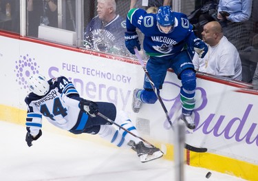 Winnipeg Jets' Josh Morrissey, left, and Vancouver Canucks' Elias Pettersson, of Sweden, collide during the second period of an NHL hockey game in Vancouver, on Monday November 19, 2018. THE CANADIAN PRESS/Darryl Dyck