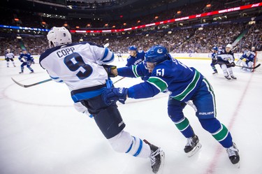 Vancouver Canucks' Troy Stecher, right, checks Winnipeg Jets' Andrew Copp during the third period of an NHL hockey game in Vancouver, on Monday November 19, 2018. THE CANADIAN PRESS/Darryl Dyck