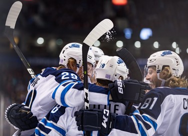 Winnipeg Jets' Patrik Laine (29), of Finland, Bryan Little (18), Kyle Connor (81) and Tyler Myers, back, celebrate Little's goal against the Vancouver Canucks during the first period of an NHL hockey game in Vancouver, on Monday November 19, 2018. THE CANADIAN PRESS/Darryl Dyck