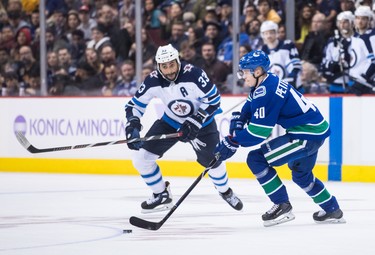 Vancouver Canucks' Elias Pettersson (40), of Sweden, skates with the puck past Winnipeg Jets' Dustin Byfuglien during the third period of an NHL hockey game in Vancouver, on Monday November 19, 2018. THE CANADIAN PRESS/Darryl Dyck