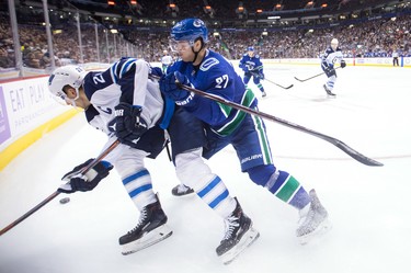 Vancouver Canucks' Ben Hutton, right, checks Winnipeg Jets' Blake Wheeler during the third period of an NHL hockey game in Vancouver, on Monday November 19, 2018. THE CANADIAN PRESS/Darryl Dyck