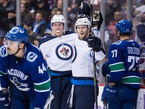 Winnipeg Jets' Patrik Laine, (left) and Kyle Connor celebrate Laine's second goal during the third period of an NHL hockey game in Vancouver, on Monday.