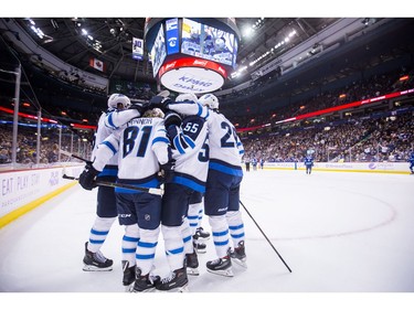 Winnipeg Jets' Blake Wheeler, from left to right, Kyle Connor, Mark Scheifele, Patrik Laine, of Finland, and Dustin Byfuglien, back, celebrate Connor's goal against the Vancouver Canucks during the first period of an NHL hockey game in Vancouver, on Monday November 19, 2018. THE CANADIAN PRESS/Darryl Dyck
