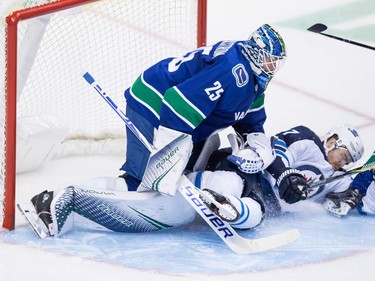 Winnipeg Jets' Adam Lowry, right, crashes into Vancouver Canucks goalie Jacob Markstrom, of Sweden, during the second period of an NHL hockey game in Vancouver, on Monday November 19, 2018. THE CANADIAN PRESS/Darryl Dyck ORG XMIT: VCRD117