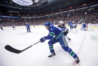 Vancouver Canucks' Michael Del Zotto (4) is checked by Winnipeg Jets' Mathieu Perreault (85) during the first period of an NHL hockey game in Vancouver, on Monday November 19, 2018. THE CANADIAN PRESS/Darryl Dyck