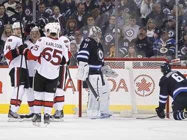 Ottawa Senators' Chris Neil (25), Colin Greening (14), and Erik Karlsson (65) celebrate Neil's goal against Winnipeg Jets' goaltender Ondrej Pavelec (31) and Ron Hainsey (6) during second period NHL action in Winnipeg on Saturday, January 19, 2013. THE CANADIAN PRESS/John Woods