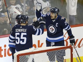 Jets' Nikolaj Ehlers (27), Mark Scheifele (55) and Blake Wheeler (26) celebrate Ehlers' game winning goal against Colorado Avalanche's goaltender Semyon Varlamov (1) during third period on Friday night. (THE CANADIAN PRESS/John Woods)