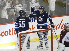 Jets' Nikolaj Ehlers (27), Mark Scheifele (55) and Blake Wheeler (26) celebrate Ehlers' game winning goal against Colorado Avalanche's goaltender Semyon Varlamov (1) during third period on Friday night. (THE CANADIAN PRESS/John Woods)