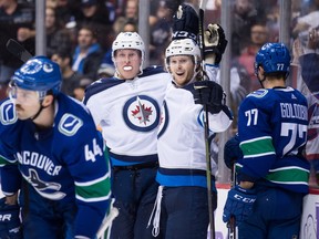 Winnipeg Jets' Patrik Laine, back leftand Kyle Connor, back right, celebrate Laine's second goal against the Canucks in Vancouver on Monday night. (THE CANADIAN PRESS/Darryl Dyck)