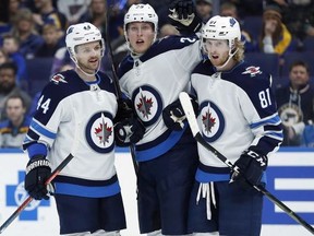 Winnipeg Jets' Patrik Laine, of Finland, is congratulated by Josh Morrissey (44) and Kyle Connor (81) after scoring during the first period of an NHL hockey game against the St. Louis Blues, Saturday, Nov. 24, 2018, in St. Louis.