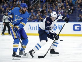 Winnipeg Jets' Tyler Myers (57) and St. Louis Blues' Pat Maroon (7) watch the puck during the first period of an NHL hockey game Saturday, Nov. 24, 2018, in St. Louis.