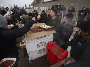 Prime Minister Justin Trudeau enjoys some bannock at a street party after announcing to the residents the opening of the repaired railway in Churchill, Manitoba Thursday, November 1, 2018. Prime Minister Justin Trudeau visited Churchill today to announce the opening of the railway and the Port of Churchill. THE CANADIAN PRESS/John Woods