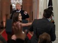 U.S. President Donald Trump looks on as a White House aide tries to take away a microphone from CNN reporter Jim Acosta during a news conference at the White House in Washington, Wednesday, Nov. 7, 2018.