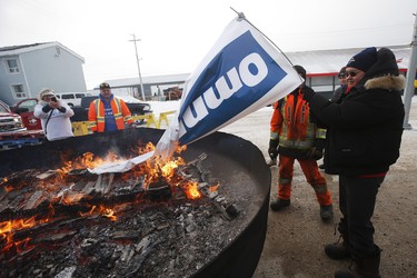 Patricia Kandiurin burns an OmniTrax banner at a street party celebrating the opening of the repaired railway in Churchill, Manitoba Thursday, November 1, 2018. Prime Minister Justin Trudeau visited Churchill today to announce the opening of the railway and the Port of Churchill. THE CANADIAN PRESS/John Woods