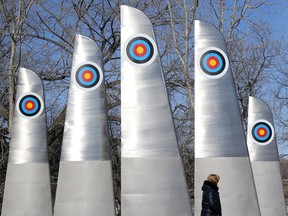 A woman walks past a Winnipeg Arts Council public art installation called High Five on Waterfront Drive, near The Forks.