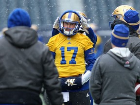 Chris Streveler gets help with his hood from Andrew Harris during Winnipeg Blue Bombers practice on Wednesday.