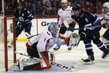 Winnipeg Jets forward Andrew Copp (right) swats at a puck near the glove of Washington Capitals goaltender Pheonix Copley in Winnipeg on Wed., Nov. 14, 2018. Kevin King/Winnipeg Sun/Postmedia Network