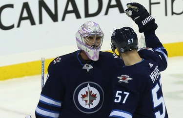 Winnipeg Jets goaltender Connor Hellebuyck is congratulated by defenceman Tyler Myers after defeating the Washington Capitals in Winnipeg on Wed., Nov. 14, 2018. Kevin King/Winnipeg Sun/Postmedia Network