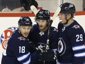 Winnipeg Jets forward Kyle Connor is congratulated on his empty-net goal against the Washington Capitals in Winnipeg by Bryan Little (left) and Patrik Laine on Wed., Nov. 14, 2018. Kevin King/Winnipeg Sun/Postmedia Network