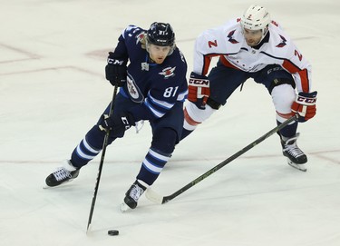 Winnipeg Jets forward Kyle Connor (left) shields the puck from Washington Capitals defenceman Matt Niskanen in Winnipeg on Wed., Nov. 14, 2018. Kevin King/Winnipeg Sun/Postmedia Network