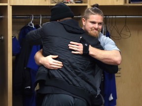 Adam Bighill (right) hugs Chris Randle in the Winnipeg Blue Bombers locker room on Monday. Bighill is the biggest name on the list of 42 Blue Bombers who will become free agents on Feb. 12.