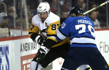 Pittsburgh Penguins centre Sidney Crosby (left) battles with Winnipeg Jets defenceman Joe Morrow in Winnipeg on Tues., Nov. 27, 2018. Kevin King/Winnipeg Sun/Postmedia Network