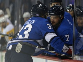 Winnipeg Jets defenceman Ben Chiarot (right) helps Dustin Byfuglien get on the bench after he collide with Pittsburgh Penguins defenceman Jamie Oleksiak in Winnipeg on Tues., Nov. 27, 2018. Kevin King/Winnipeg Sun/Postmedia Network