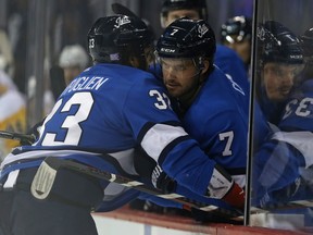 Winnipeg Jets defenceman Ben Chiarot (right) helps Dustin Byfuglien get on the bench after he collide with Pittsburgh Penguins defenceman Jamie Oleksiak in Winnipeg on Tues., Nov. 27, 2018. Kevin King/Winnipeg Sun/Postmedia Network