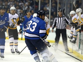 Winnipeg Jets defenceman Dustin Byfuglien (33) collides with Pittsburgh Penguins defenceman Jamie Oleksiak in Winnipeg on Tues., Nov. 27, 2018. Byfuglien could return to action Friday against the Blues. Kevin King/Winnipeg Sun/Postmedia Network