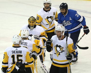 Pittsburgh Penguins goaltender Casey DeSmith celebrates a win over Dustin Byfuglien (right) and the Winnipeg Jets in Winnipeg on Tues., Nov. 27, 2018. Kevin King/Winnipeg Sun/Postmedia Network