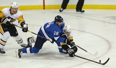 Winnipeg Jets centre Bryan Little (18) swings at a puck as Pittsburgh Penguins defenceman Jack Johnson dives in Winnipeg on Tues., Nov. 27, 2018. Kevin King/Winnipeg Sun/Postmedia Network