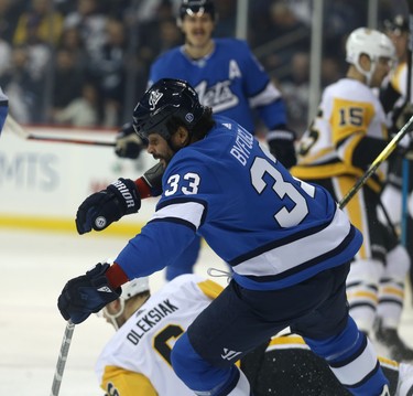 Winnipeg Jets defenceman Dustin Byfuglien topples after colliding with Pittsburgh Penguins defenceman Jamie Oleksiak in Winnipeg on Tues., Nov. 27, 2018. Kevin King/Winnipeg Sun/Postmedia Network