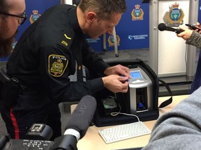Winnipeg Police Service impaired driving countermeasures coordinator Const. Stephane Fontaine demonstrates the Drager DrugTest 5000 roadside drug screening device at a press conference at police headquarters on Friday, Nov. 30, 2018 to announce the start of the 2018 Festive Season Checkstop program. The program will begin on Saturday, Dec. 1, 2018 and will run every day during the month of December. Winnipeg police announced that Checkstop units will also be equipped with the Drager DrugTest 5000 roadside drug screening device. GLEN DAWKINS/Winnipeg Sun/Postmedia Network