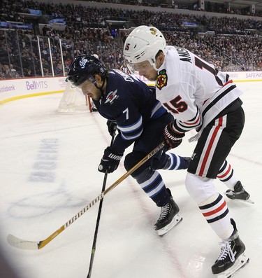 Winnipeg Jets defenceman Ben Chiarot (left) and Chicago Blackhawks centre Artem Anisimov battle for a loose puck in Winnipeg on Thurs., Nov. 29, 2018. Kevin King/Winnipeg Sun/Postmedia Network