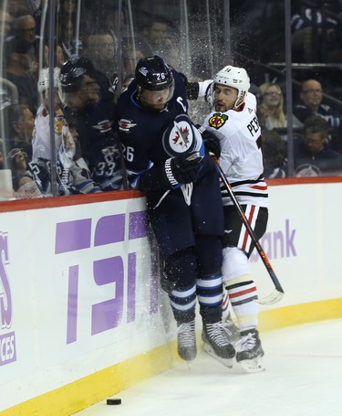 Winnipeg Jets forward Blake Wheeler (left) is ran into the end boards by Chicago Blackhawks forward Brendan Perlini in Winnipeg on Thurs., Nov. 29, 2018. Kevin King/Winnipeg Sun/Postmedia Network