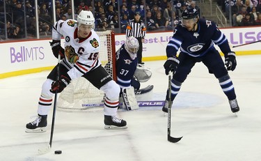 Chicago Blackhawks centre Jonathan Toews (left) circles as he is defended by Winnipeg Jets defenceman Ben Chiarot in Winnipeg on Thurs., Nov. 29, 2018. Kevin King/Winnipeg Sun/Postmedia Network