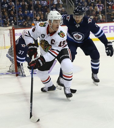 Chicago Blackhawks centre Jonathan Toews (left) is defended by Winnipeg Jets defenceman Ben Chiarot in Winnipeg on Thurs., Nov. 29, 2018. Kevin King/Winnipeg Sun/Postmedia Network