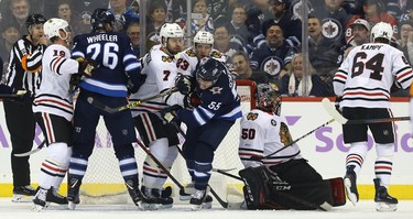 Winnipeg Jets centre Mark Schiefele (centre) is roughed up by Chicago Blackhawks defence men Brent Seabrook (7) and Brandon Manning (23) in Winnipeg on Thurs., Nov. 29, 2018. Kevin King/Winnipeg Sun/Postmedia Network