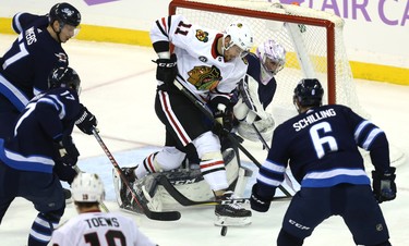 Winnipeg Jets goaltender Connor Hellebuyck collides with Chicago Blackhawks forward Brendan Perlini in Winnipeg on Thurs., Nov. 29, 2018. Kevin King/Winnipeg Sun/Postmedia Network