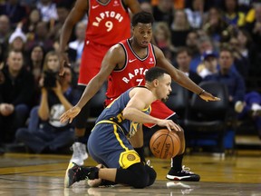 Stephen Curry of the Golden State Warriors dribbles on his knees while being guarded by Kyle Lowry of the Toronto Raptors at Oracle Arena on December 12, 2018 in Oakland, California. (Photo by Ezra Shaw/Getty Images)