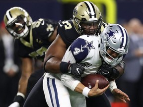 ARLINGTON, TEXAS - NOVEMBER 29: Dak Prescott #4 of the Dallas Cowboys is sacked by David Onyemata #93 of the New Orleans Saints in the first quarter at AT&T Stadium on November 29, 2018 in Arlington, Texas. (Photo by Ronald Martinez/Getty Images)