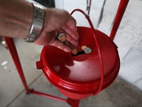 A donation is made into a Salvation Army red kettle. (Photo by Joe Raedle/Getty Images)